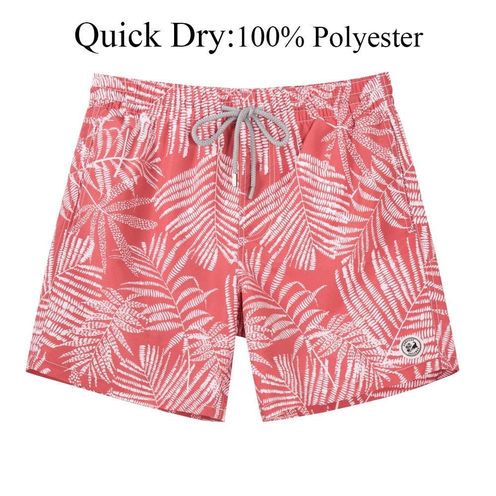 Red swim shorts with white leaf pattern on a white background